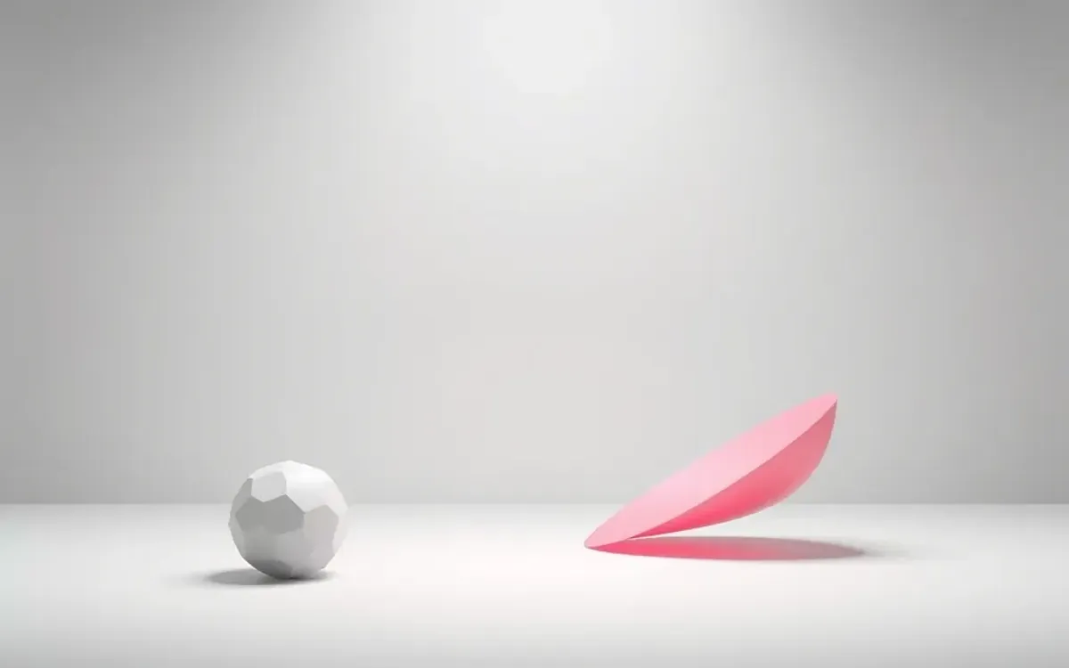 Esfera cinza e papel rosa em um piso e fundo cinza claro.
